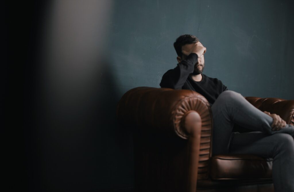 man sitting in dark room feeling guilt