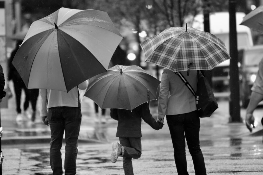 child walking with parents holding hands