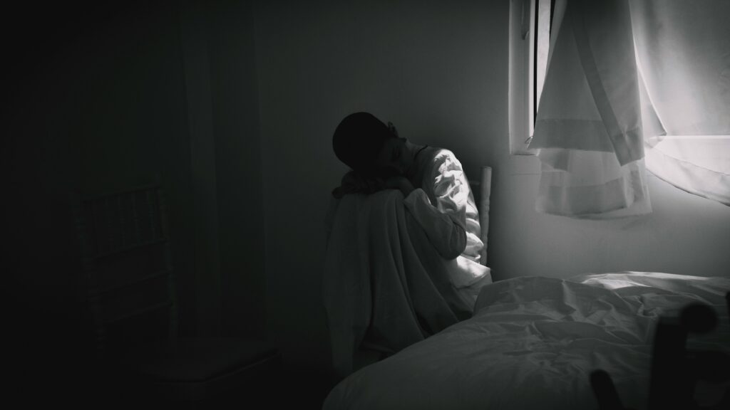 Girl sitting alone in a room: loneliness is a universal human emotion that is complex and unique to each individual. 